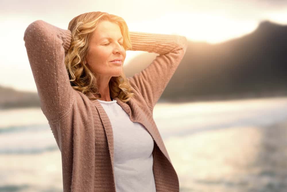Midlife woman stretching with eyes closed